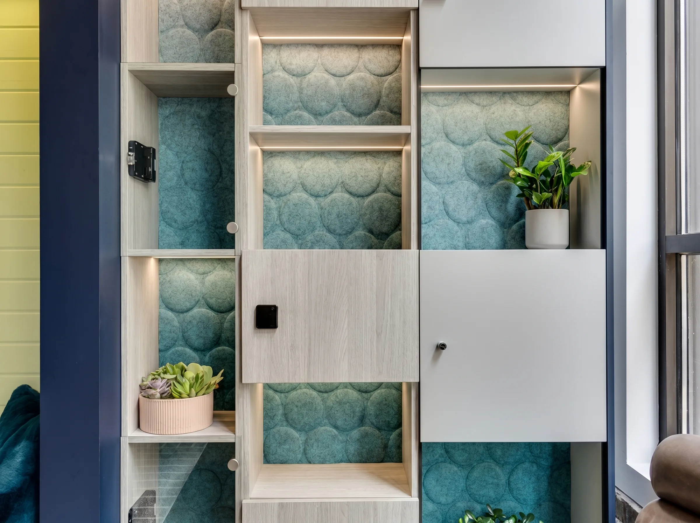 Teal scalloped acoustic sound dampening material as backing panels inside open cubbies and casework