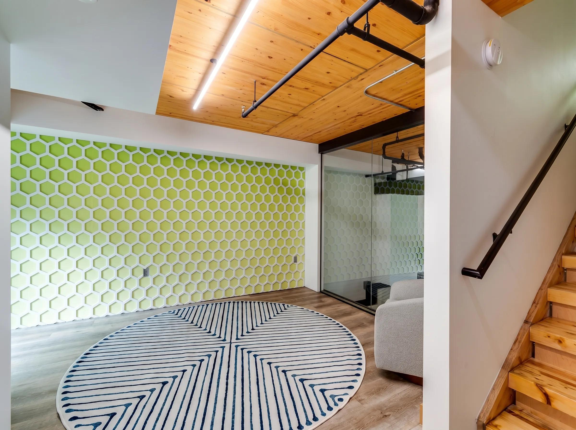Lime-green hexagonal acoustic foam panels covering full wall in creative office environment