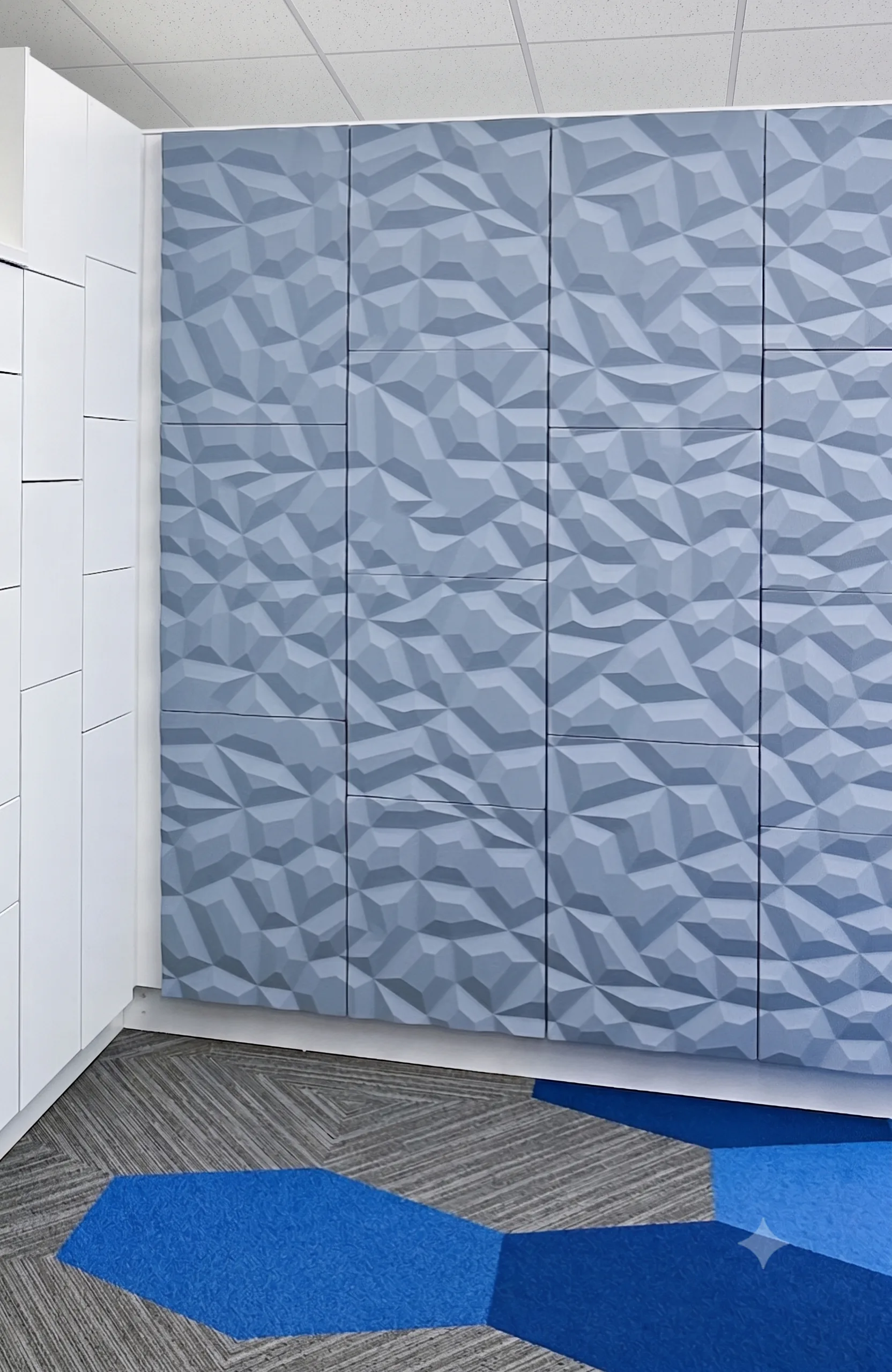 Geometric faceted vinyl wrap locker wall in showroom