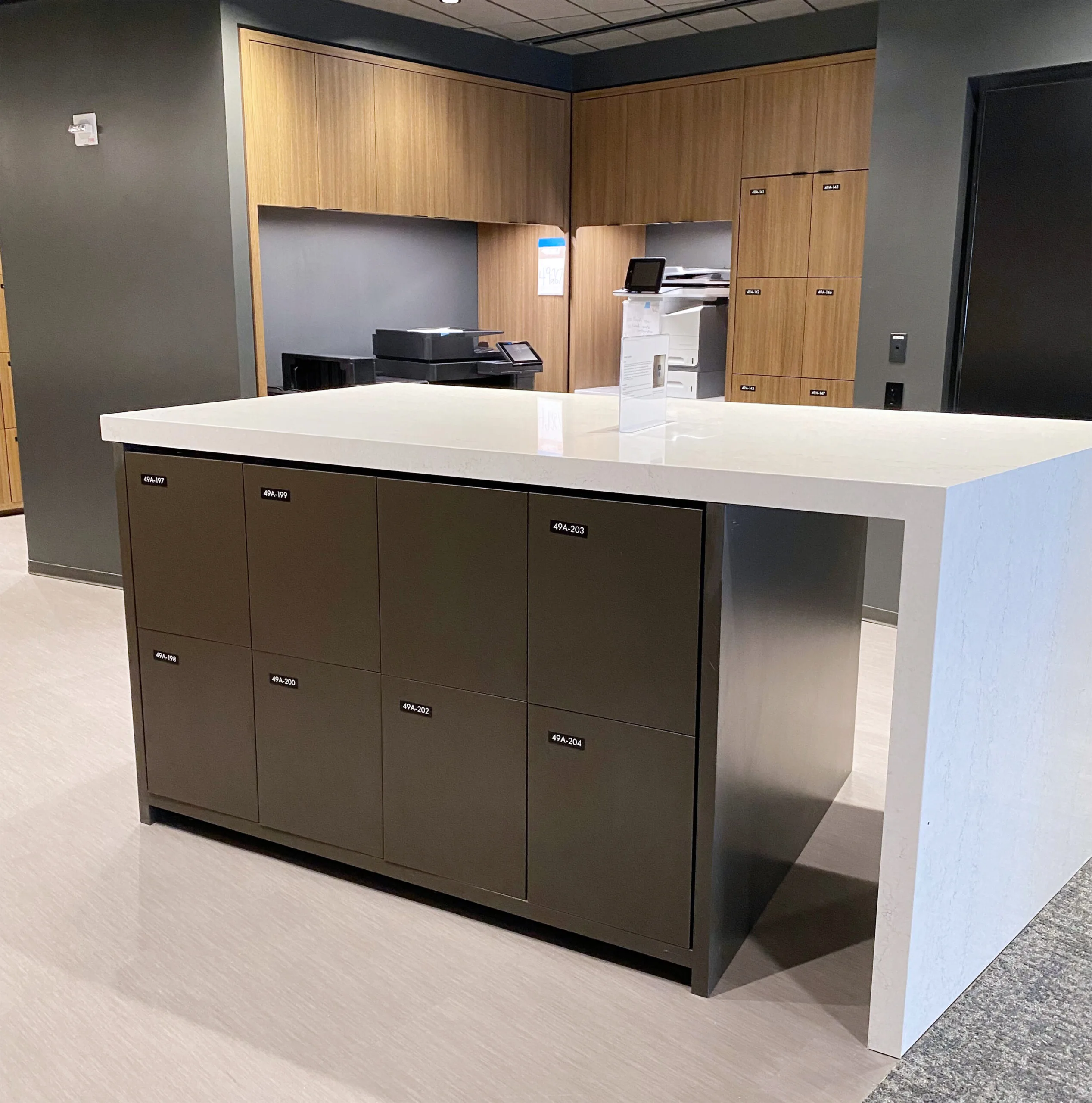 Square locker island with white quartz countertop in corporate office, AIG