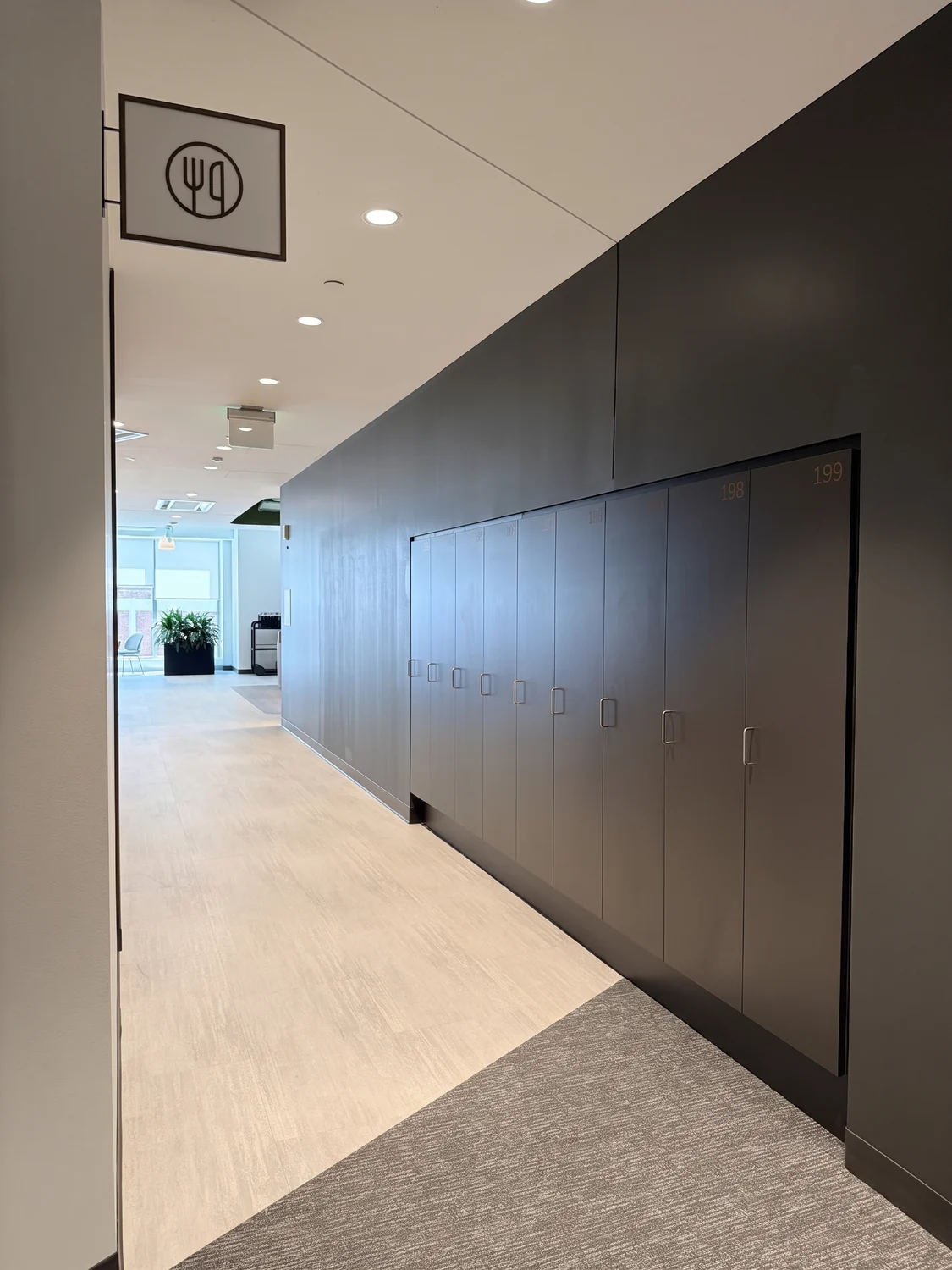 Installed full-height charcoal storage cabinets running along a light corridor
