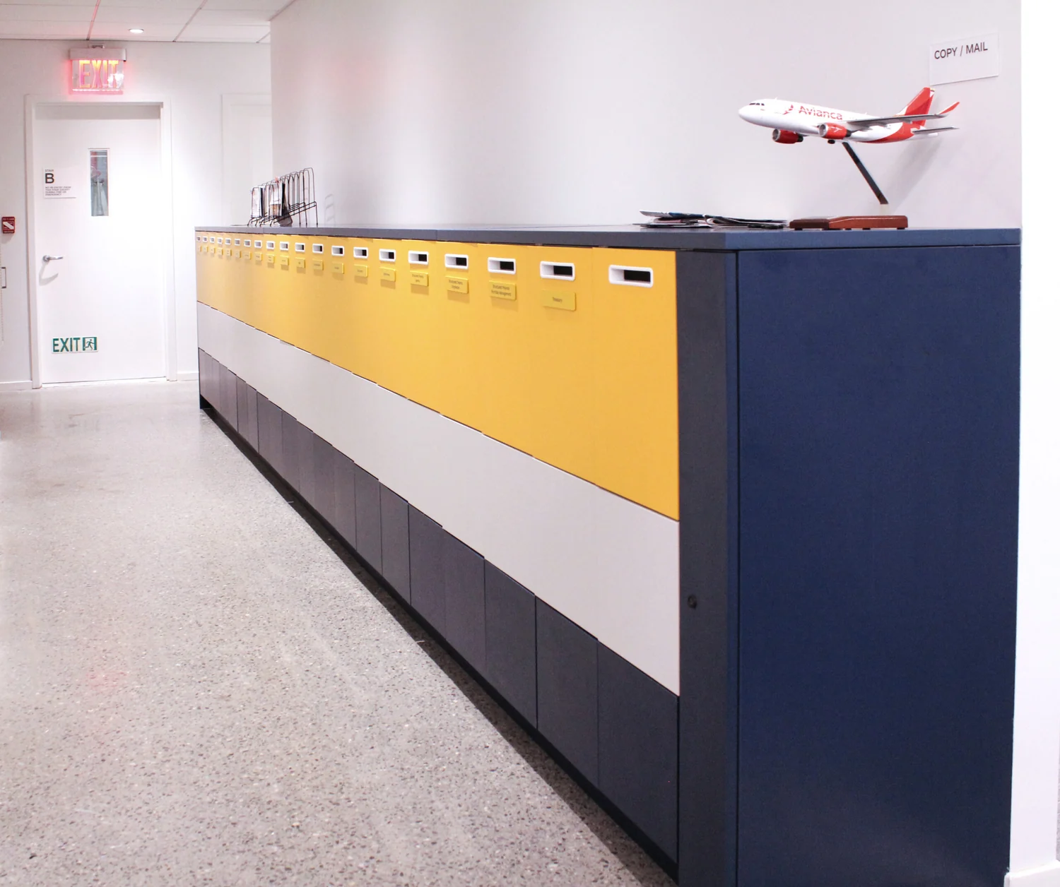Installed horizontal mail and storage run in navy, white, and yellow color bands
