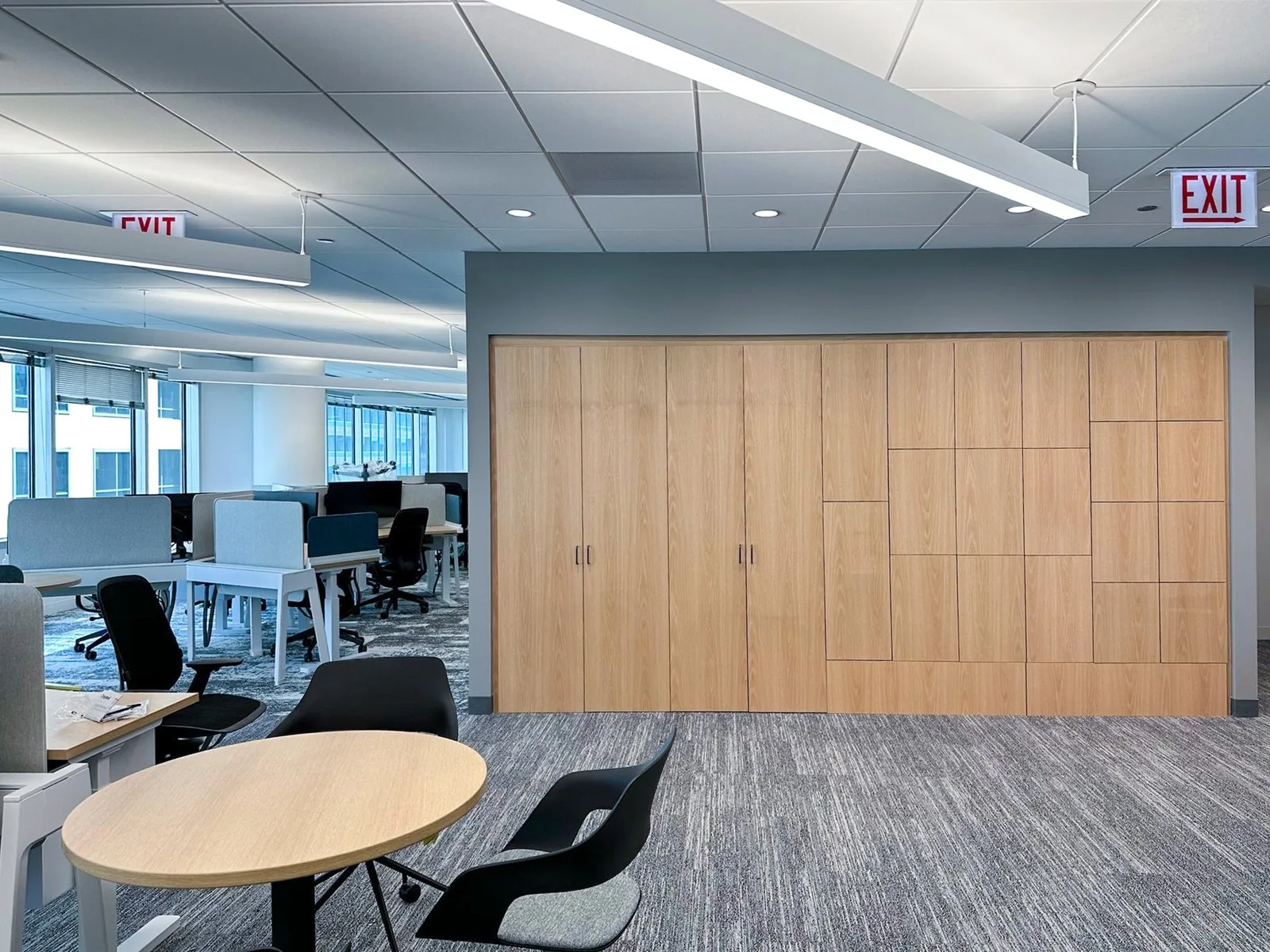 Full-height oak storage wall running the length of an open office