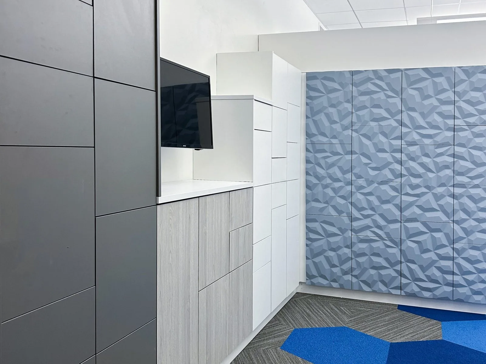 Graphite locker bank meeting a run of faceted-texture locker doors in pale blue