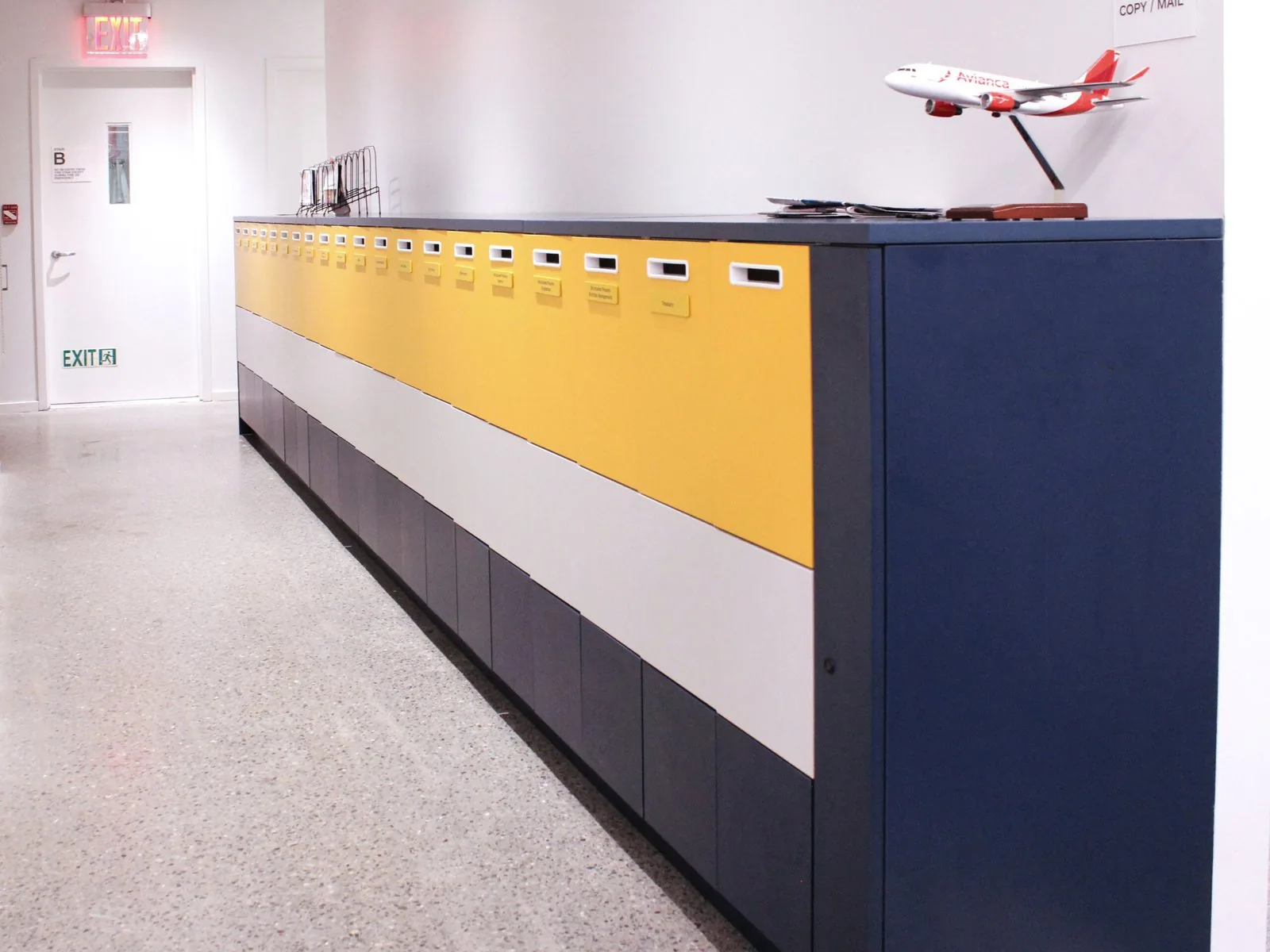 Long horizontal mail and storage run in navy, white, and yellow color bands